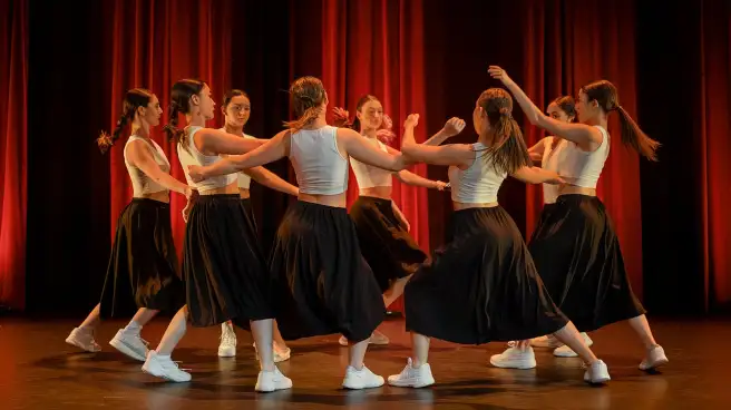 A vibrant Dance Team of young women performing energetically on stage, showcasing their talent and enthusiasm.