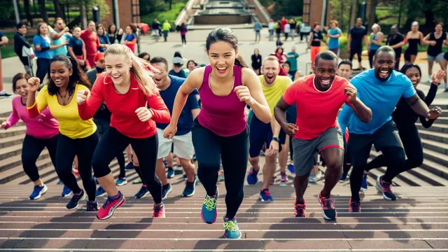 A team of people racing up stairs in a spirited step team challenge, emphasizing collaboration and athleticism in action