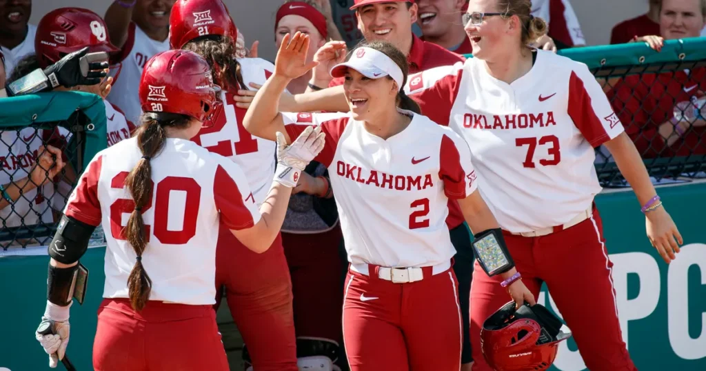 A joyful girls softball team celebrates their victory after a game, showcasing teamwork and camaraderie in sports.