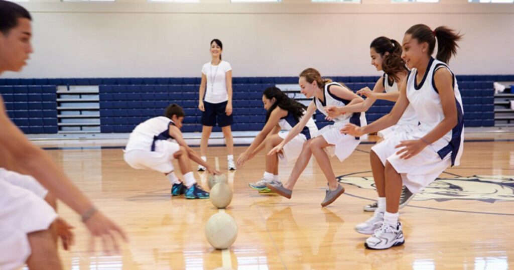 A group of girls energetically playing basketball on a court, showcasing teamwork and athleticism for the Dodgeball Tournament Name Ideas.
